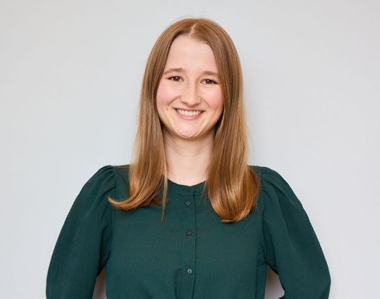 Duale Studentin bei dmTECH lächelt freundlich in die Kamera.