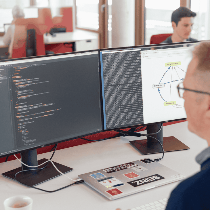 Softwareentwickler schaut auf Bildschirm mit Code