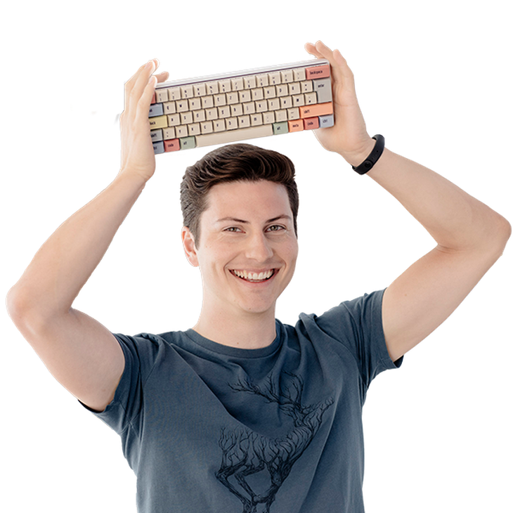 Junger Mann im T-Shirt hält eine bunte Entwickler-Tastatur über seinen Kopf