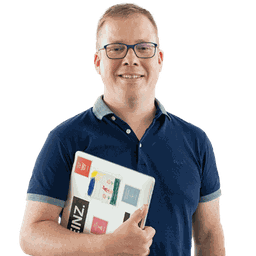 Junger Mann mit Brille und Laptop im Arm lächelt