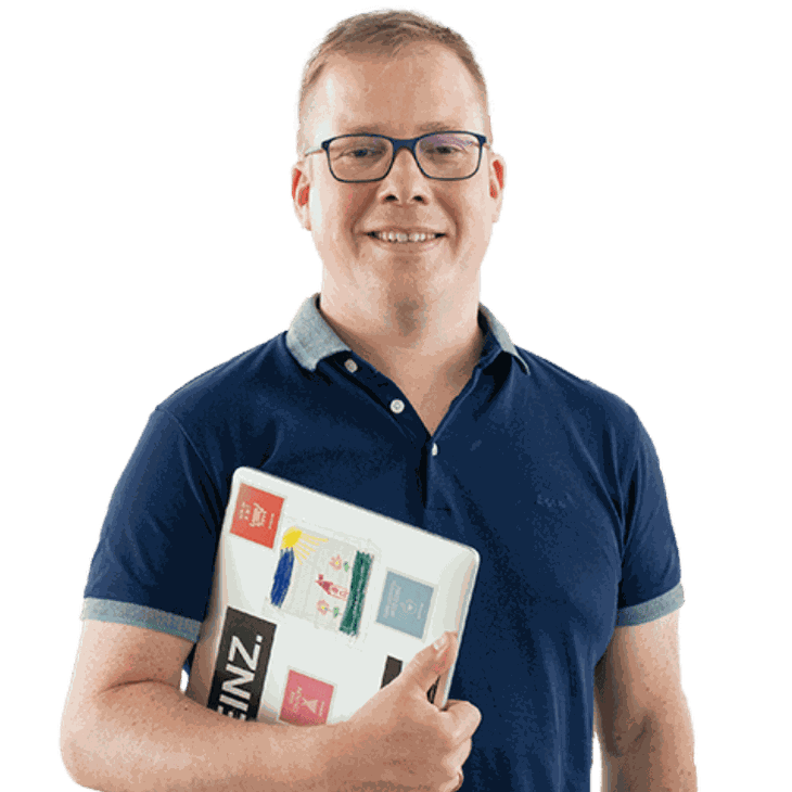 Junger Mann mit Brille und Laptop im Arm lächelt