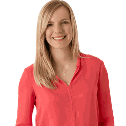 Junge, blonde Frau in roter Bluse lächelt in Kamera