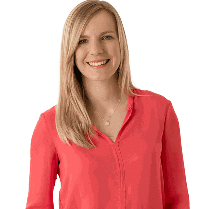 Junge, blonde Frau in roter Bluse lächelt in Kamera