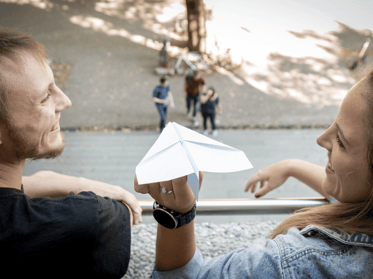 Zwei IT-interessierte Schüler lassen einen Papierflieger fliegen und freuen sich auf ihre Zukunft