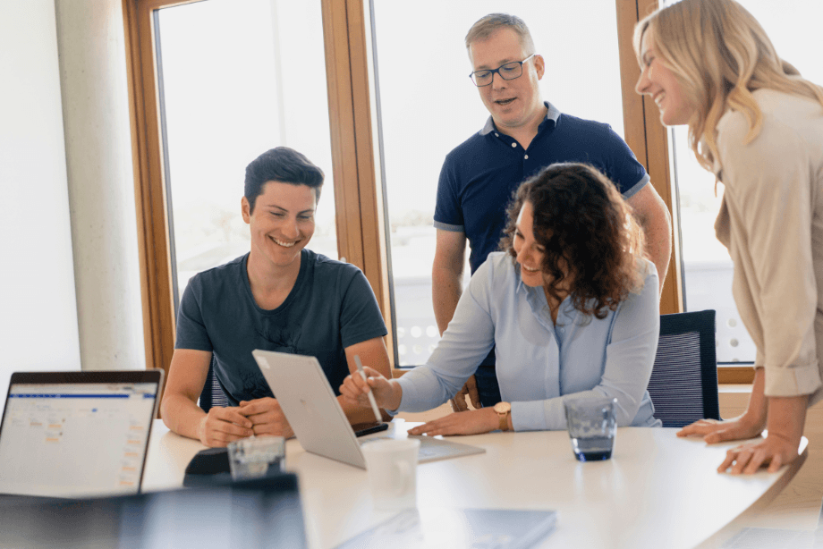 Vier IT-Expertinnen und -Experten lachen gemeinsam